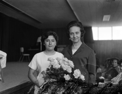 Eva Samano de López Mateos junto a un niño en un auditorio después de festival escolar, retrato