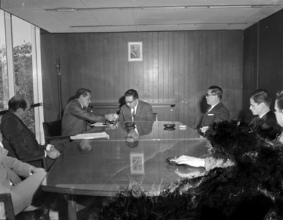 Ejecutivo ofrece cigarrillos a empresario durante reunión en oficina