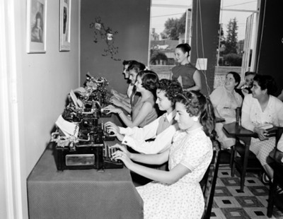Mujeres redactan documento en maquína de escribir