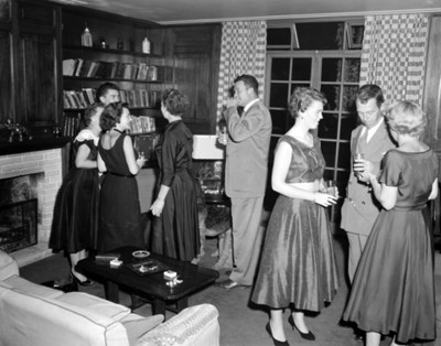 Hombres y mujeres durante reunión social en la sala de una casa