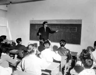 Profesor enseña notas musicales a alumnos
