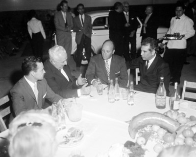 Ejecutivos conversan en evento en un taller automotríz