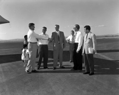 Empresarios saludandose en la pista de un aeropuerto