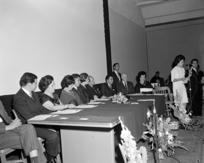 Mujer habla por micarofono durante una conferencia
