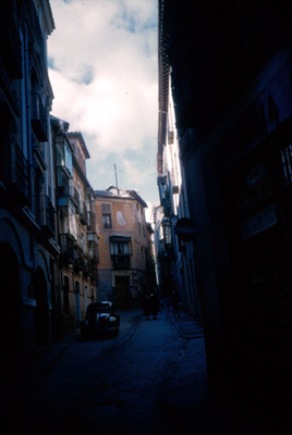 Gente camina por un callejon de Toledo