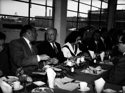 Harry H. Steel, empresario dialogando con un hombre, durante un banquete