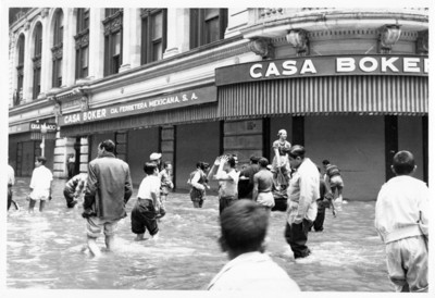 Gente frente al edificio Boker camina por la calle inundada