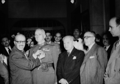 Juan Manuel Torrea, general es condecorado por un funcionario durante un evento social, retrato de grupo