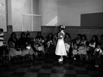 Enfermera da plática a mujeres con niños