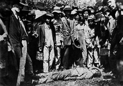 Gente observa el cadáver de un hombre tendido en el suelo