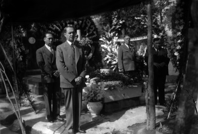 Emilio Portes Gil y otras personas hacen guardia de honor en un cementerio