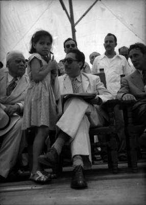 Miguel Alemán Valdés saludando a una niña, lo acompañan Ramón Beteta y Enrique Pérez Arce