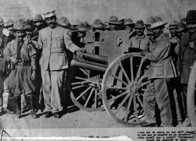 Francisco Villa y revolucionarios de pie junto con artillería, retrato de grupo