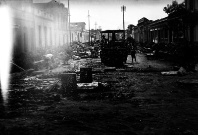 Trabajadores con aplanadora en proceso constructivo, primer cuadro de la ciudad