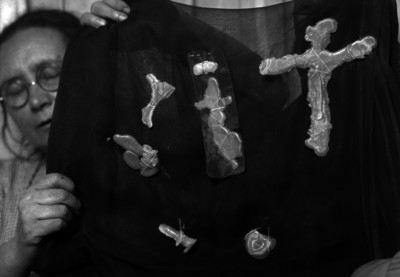Mujer mostrando figurillas de cerámica, sujetas sobre una tela