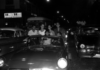 Turistas en auto convertible, por una calle de Acapulco