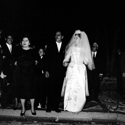 Novia caminando del brazo de un hombre entre la gente