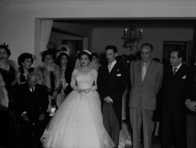 Novios acompañados de familiares y amigos en la sala de una casa el día de su boda