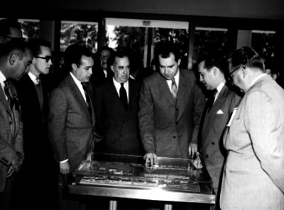 Richard Nixón y empresarios observando una maqueta de las instalaciones de la fábrica D.M.N.