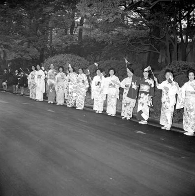 Mujeres vestidas de geishas con banderas de México en una calle de Tokio, durante la visita de Adolfo López Mateos