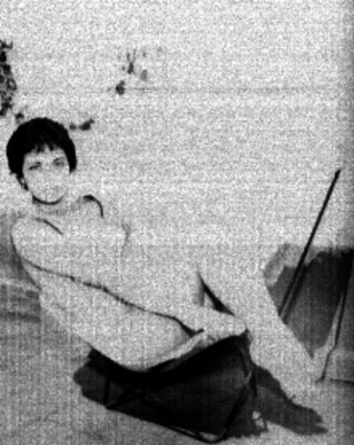 Actriz posando sentada en una silla de tela, en un jardín, retrato