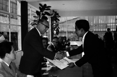 Romulo O'farril, empresario entregando un diploma a un hombre durante una ceremonia en una escuela