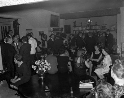 Hombres y mujeres reunidos en la sala de una casa
