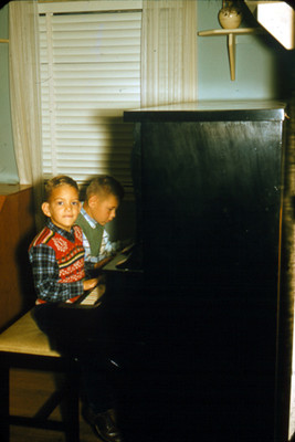 Niños sentados tocan el piano
