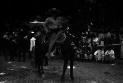Nicolás Zapata monta a caballo, al fondo campesinos lo observan