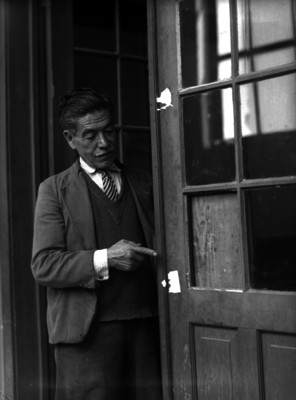 Hombres mostrando los daños causados a una puerta durante un delito