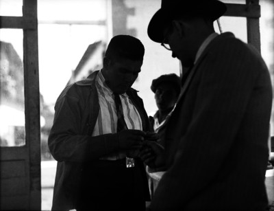 Agente del ministerio público revisando la identificación de un hombre