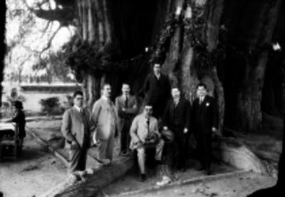 Romeo Ortega y Jenaro V. Vázquez con funcionarios frente al árbol del tule, retrato de grupo