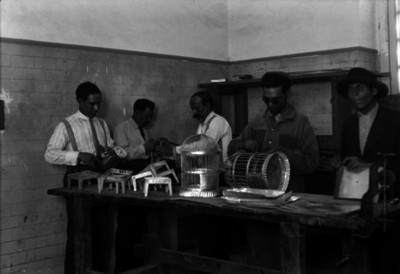 Hombres elaboran jaulas y bases para braceros un en taller
