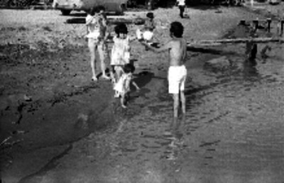 Familia de turistas jugando en la playa