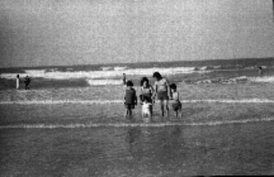 Familia de turistas paseando en la playa, retrato de familia