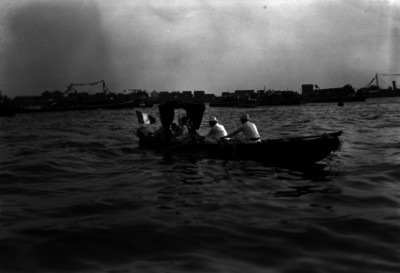 Hombres en un bote, transportando a la reina de las fiestas