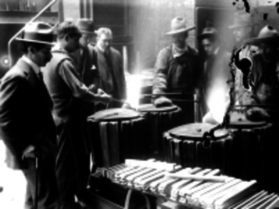 Obreros fundiendo metal en una casa de moneda