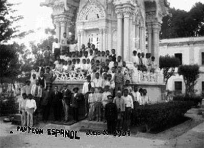 Hombres frente a una tumba, en el panteón Español
