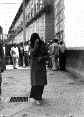 Mujer cubriendose el rostro, en la penitenciaría del Distrito Federal