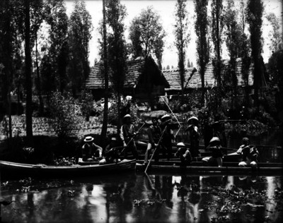 Hombres vestidos de revolucionarios escenificando una batalla abordo de unas trajineras en el canal de Xochimilco