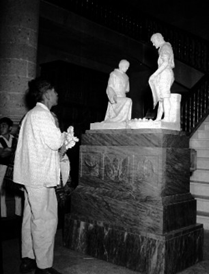 Indígena portando flores ante la imágen de Juan Diego