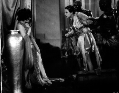 Hombre acecha a una mujer mientras lo detienen dos esclavos negros, escena de película