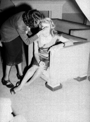 Mujer retocando el maquillaje a una artista