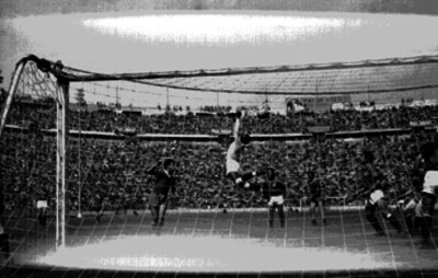 Portero del Independiente salta para evitar un tiro de gol