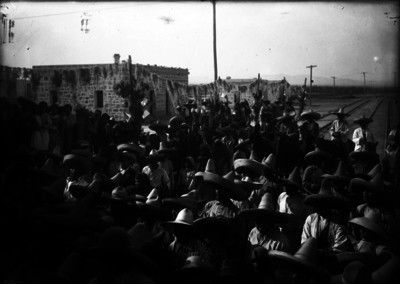 Reunión de campesinos junto a vías férreas de un poblado