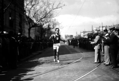 Atleta con estafeta llega a la meta de una carrera