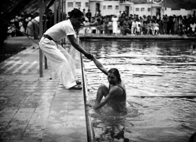 Hombre ayuda a nadadora a sair del agua