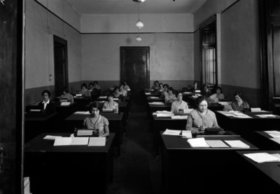 Secretarias de un archivo público, escriben a máquina