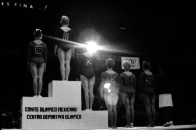 Gimnastas en el podio de gandadores, de espaldas