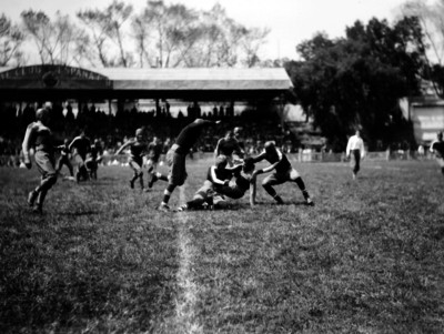 Jugadores de futbol americano taclean a contrincante en un partido en el club España